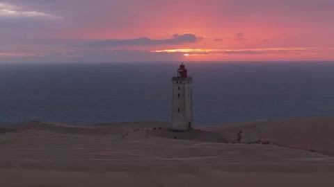 Sunset Drone Orbit Around Rubjerg Knude Lighthouse Above the Sandy North Sea Stock Footage 346257696