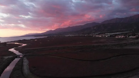 Sunset Drone Over Marsh with Mountains Ocean and Vibrant Colors 库存影片 100656717