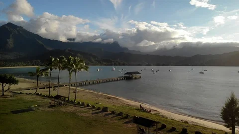 Sunset drone over shoreline with mountains 4K Stock Footage 128952671