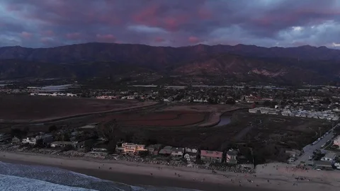 Sunset Drone Pull Back from Oceanfront Houses to Reveal Mountains and Vibrant 库存影片 100665471
