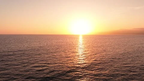 Sunset Drone Pullback Over Ocean Waves and Horizon in 4K Stock Footage 332327626