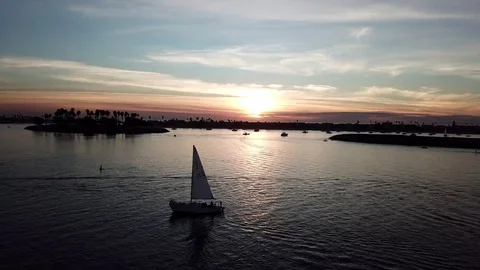 Sunset Drone view with closeup of sailboat with SUP, kayakers, palm trees 库存影片 84775334