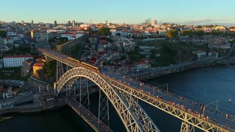 Sunset drone view of tram on Dom Luis I Bridge above the river bend Stockbeeldmateriaal 344347991