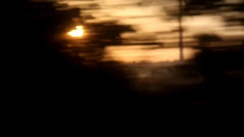 Sunset during a car drive with trees and a windmill passing by Video stock 88664451
