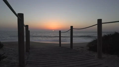 Sunset at the end of the boardwalk by the beach Video stock 163557218