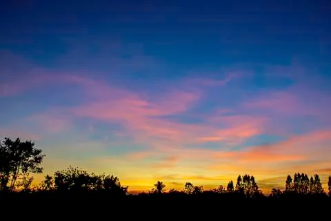 Sunset the evening light through the clouds and  trees. Stock Photos
