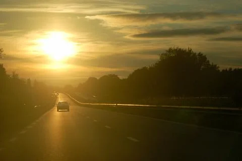 Sunset facing while driving on a road Stock Photos
