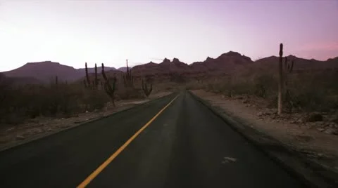 Sunset falling over a desert road Stock Footage 22421916