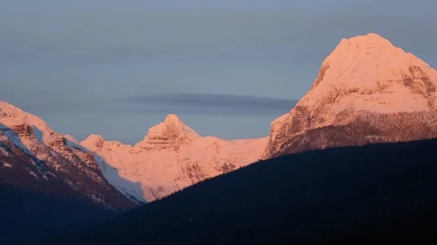 Sunset falling on the snow covered mountain tops Stock Footage 113230268