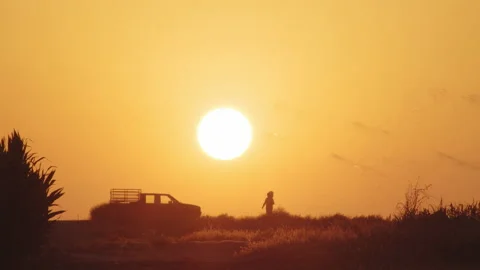 Sunset, Farmer heading back to his truck, after a hard day in the fields, 4K Stock Footage 160614739