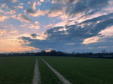 Sunset on a field with beautiful clouds Stock-Fotos