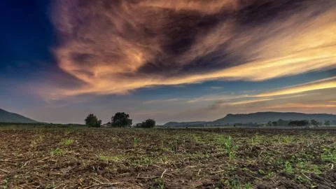 Sunset in a field with mountains in the background Stock Photos