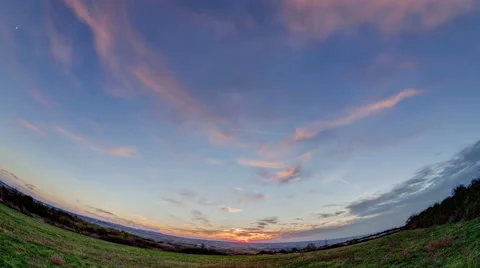 Sunset on a field outside of town with  fast moving clouds Stock Footage 54806973
