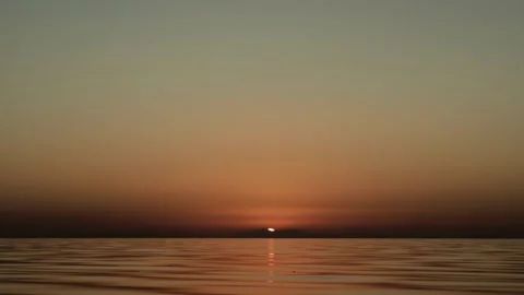 Sunset finale over ocean. Beneath blazing sky, radiant red sun crowns secluded Stock Footage 309920323