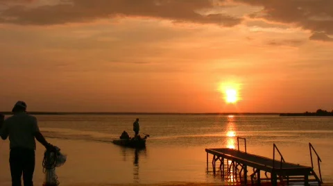 Sunset fishing boat throw net HD Stock Footage
