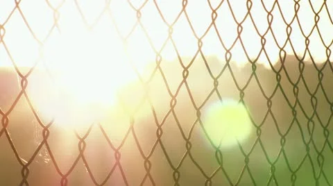Sunset flare through chain link fence Stockbeeldmateriaal 14949459