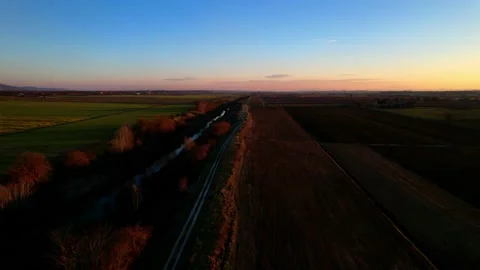 Sunset flight drone view on plowed field in Italy 4K along stream 4k Stock Footage 234143609