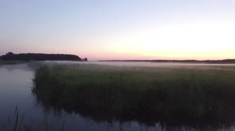 Sunset flight over calm river towards misty horizon Video stock 63655494