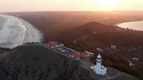 Sunset fly over of Cape Byron Lighthouse, Tallow and Clarkes Beaches Stock Footage 128957448