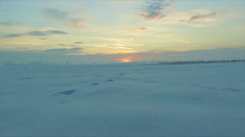 At sunset flying over a field of snow with human and animal traces Stock Footage 72403722