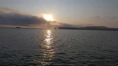 Sunset footage over the calm Pacific ocean with blue skies the background. 库存影片 104053242