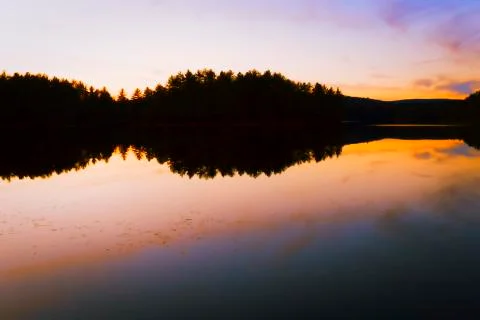 Sunset on a forest lake. Stock Photos