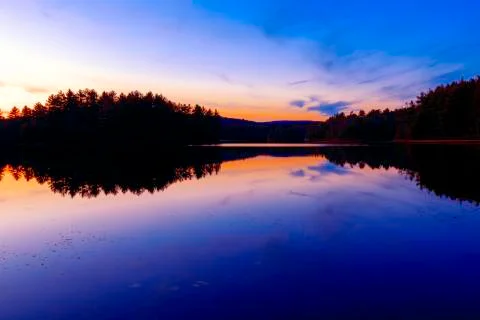 Sunset on a forest lake. Stock Photos