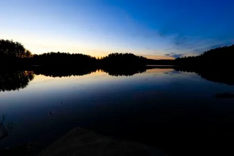 Sunset on a forest lake. Stock Photos