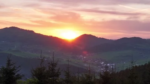 Sunset in the forest mountain rural landscape. In the valley a village with Stock-Footage 194766873