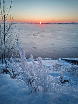 Sunset by the freezing river 스톡 사진