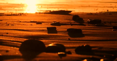 Sunset Gloden Colors On Distant Ocean Waves And Red Sandy Beach And Pebbles Stock Footage 138065243