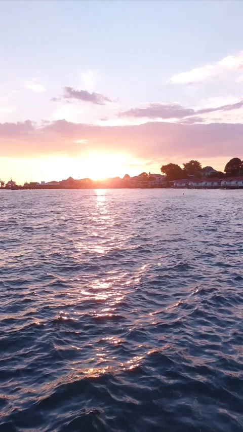 Sunset Glow on Dark Blue Sea with Silhouetted Coastal Horizon. Stock Footage 346298514