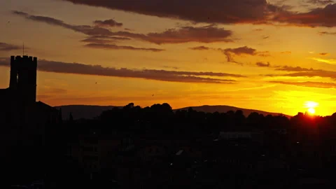 Sunset Glow Over Tower Silhouette and Layered Hills Stock Footage 256345218