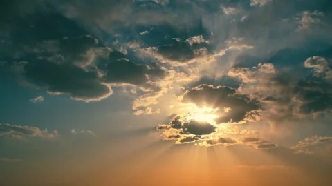 The sunset glow shines through the clouds - the time-lapse clouds drift by 動画素材 256985462