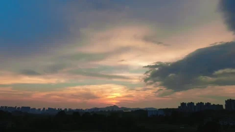 Sunset glowing over a distant urban skyline and rolling mountain silhouettes Stock-Footage 347057805