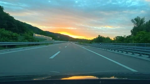 Sunset glows over highway, car moves forward. Serbia Stock Footage 340639074