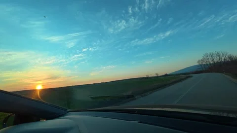 Sunset glows over winding rural road Видео 331063628
