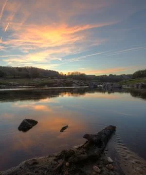 Sunset with golden clouds reflected in the river Stock Photos