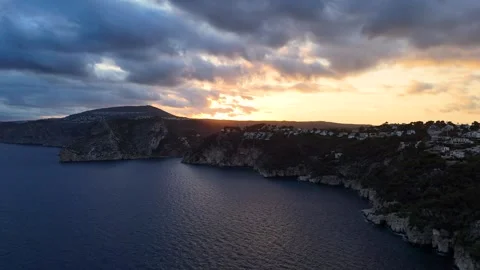 Sunset golden hour dramatic clouds coastal cliffs Javea aerial 動画素材 336643604