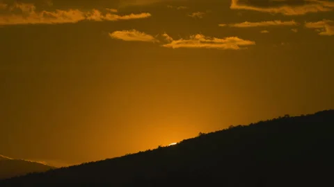 Sunset on golden sky over mountain background Stock Footage 246876574