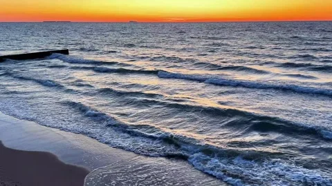 Sunset gradient from blue to orange above blue ocean water with small waves. Stock Footage 314712820