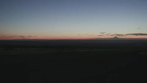 Sunset Gradient Over Open Landscape with Mountain Silhouette Video stock 332308648