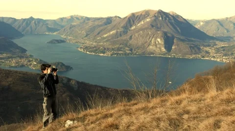 At sunset a guy looks at the view through the telescope Stock Footage 59555150