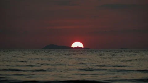 Sunset with half big red sun over the sea and island. Stock Footage 331229574