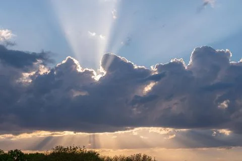 Sunset hidden behind moving clouds, thunderstorm. Stock Photos