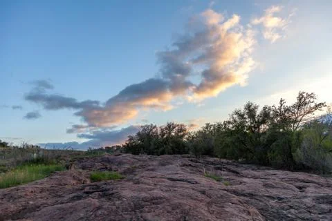 Sunset on High cloud over a Large Red Rock Stock Photos