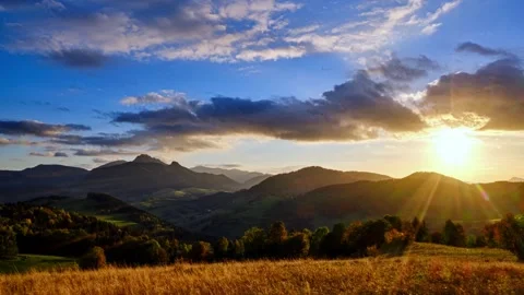 Sunset in a hilly summer landscape, rocks and rhombus illuminated by the setting Stock Footage 265658435