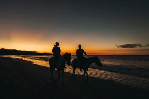 Sunset Horseback Ride on Beach Stock Photos