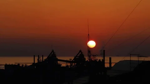 The sunset in industrial area with the sea in the background Stock Footage