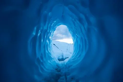 Sunset from inside a deep, dark ice cave on the Matanuska Glacier in Alaska. Stock Photos
